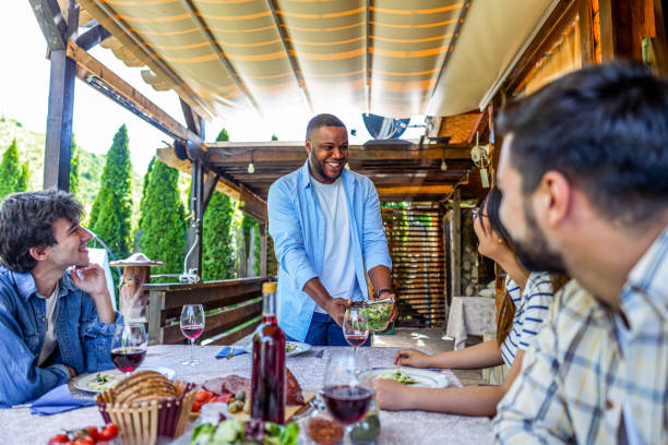 istock Man serving meal for friends in the backyard 2153875507
