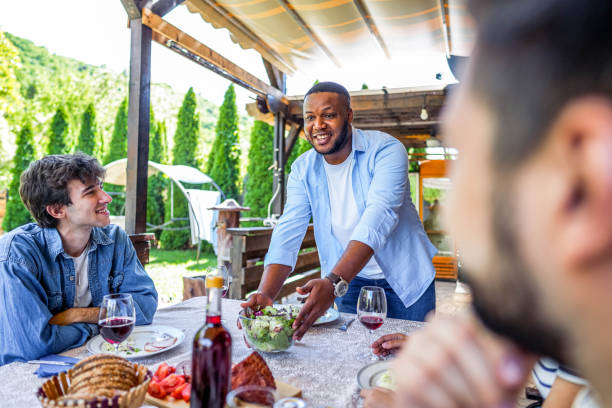 istock Man serving meal for friends in the backyard 2153875572