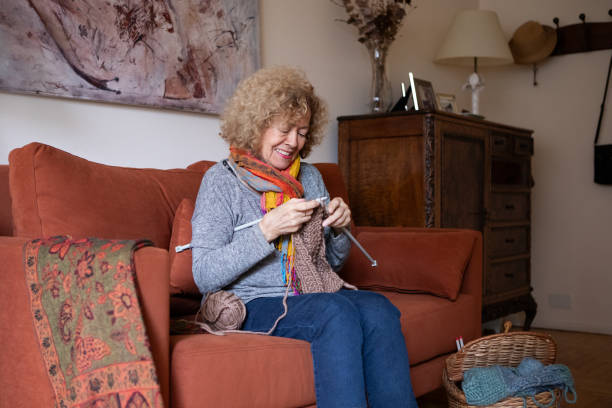 istock Elderly woman knitting at home 2153876099