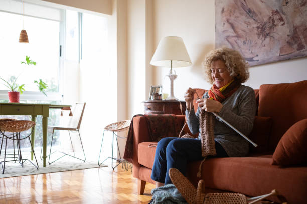 istock Elderly woman knitting at home 2153876106