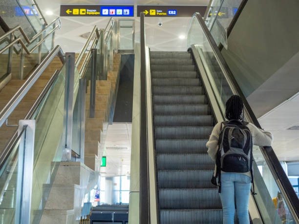 istock A young woman using the escalator at the airport 2153876999
