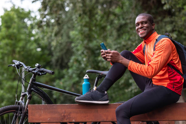 istock Happy cyclist taking a break in the park and using smart phone 2153880655
