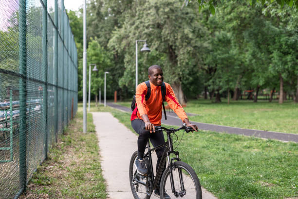 istock Man cycling on a pathway in a park on a sunny day 2153880688