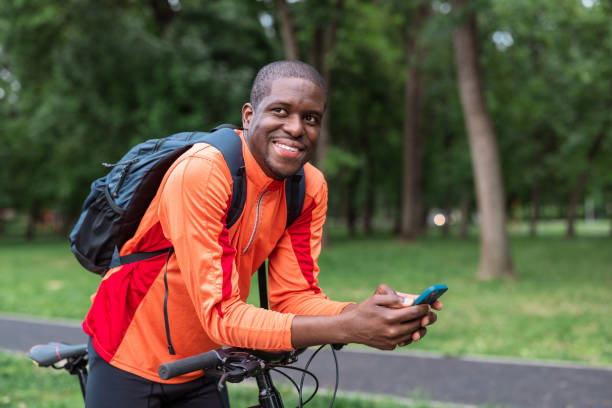 istock Smiling cyclist using smart phone during a break in the park 2153880720