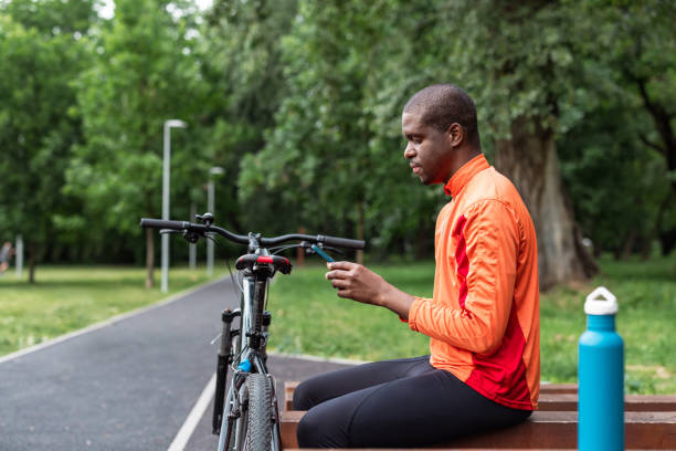 istock Man taking a break from a bike ride in a park 2153880862