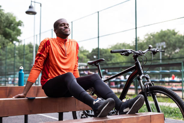 Man relaxing outdoors next to his bicycle
