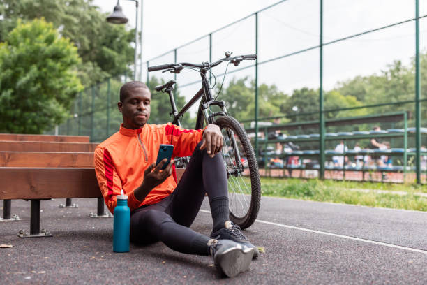istock Man resting by bicycle. He is using smart phone in park 2153880947