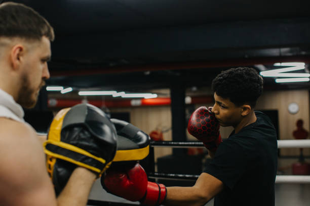 istock A young boxer practices punches with a trainer in a boxing studio. 2153881415