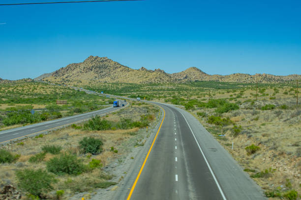 Vehicles traveling on Interstate 10 with a mountain in the backround. Photographed from an overpass.
