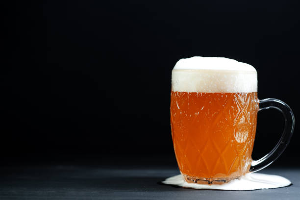 istock A mug of overflowing foamy beer on the table. Copy space 2153885659