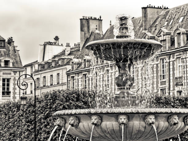 An elegant Fountain in Place des Vosges public park in Paris France