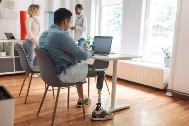 istock Inclusive workplace - employee with prosthetic limb at work 2153889495