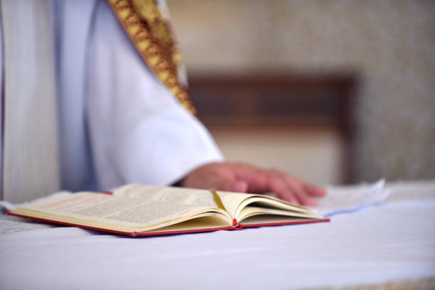 An open Bible rests on a wooden church lectern, illuminated by warm light, creating a peaceful and spiritual atmosphere in a sacred space.