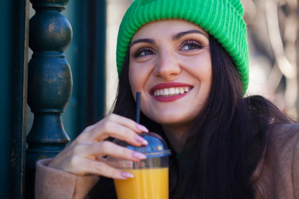 istock Beautiful young woman drinking orange juice 2153893888