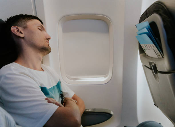 istock A young guy sleeps on an airplane near the window. 2153902983