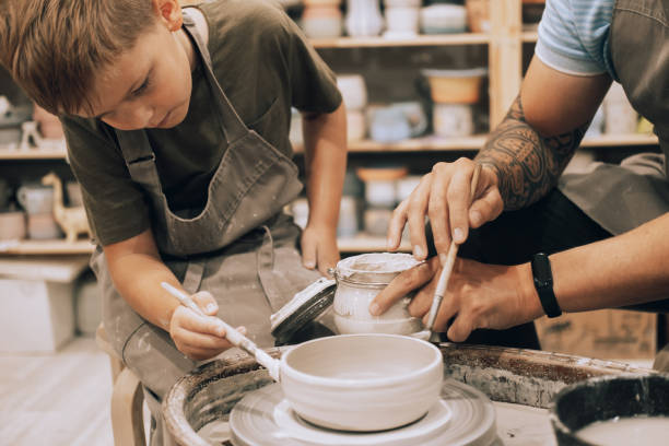 istock A young father and his seven-year-old son are engaged in creativity in a pottery workshop. 2153903541
