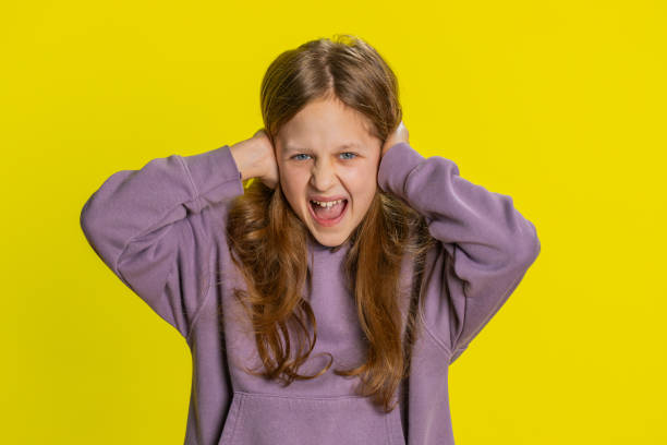 frustrated young school girl kid covering ears ignoring unpleasant noise loud voices avoiding advice - bolest-hlavy-ilustrace - stock snímky, obrázky a fotky