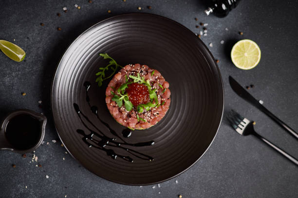 Tuna and avocado tartare on a dark ceramic plate