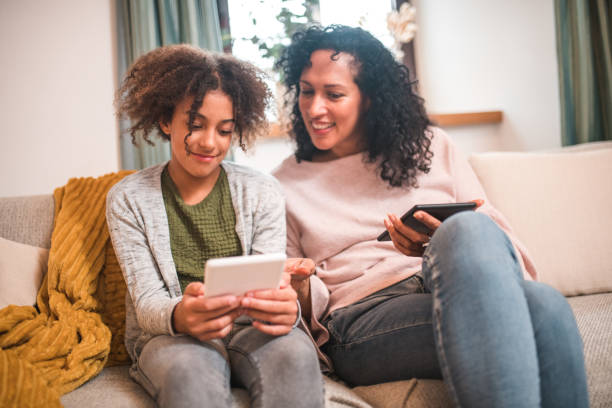 istock Quality Time with E-Readers: Hispanic Mother and Mixed Race Daughte 2153908840