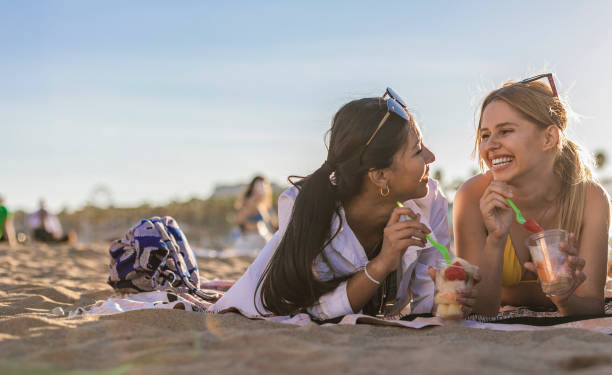 istock Friends Laughing and Enjoying Fruit on the Beach 2153920749