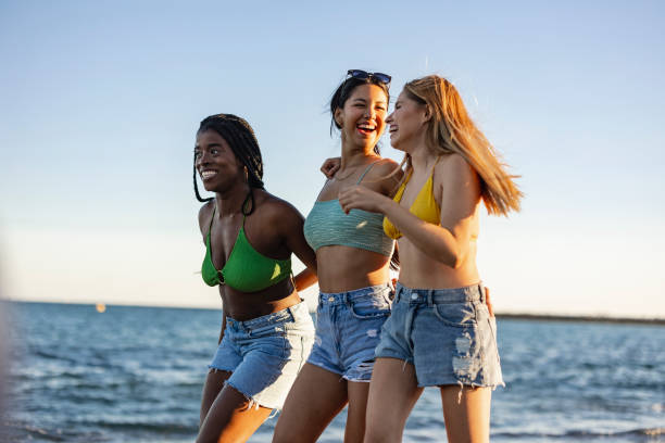 istock Friends Laughing and Walking by the Beach 2153920758