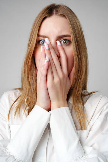 istock Young Woman in White Blouse Expressing Concern in studio 2153923661