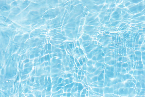 istock Blue water with ripples on the surface. Defocus blurred transparent blue colored clear calm water surface texture with splashes and bubbles. Water waves with shining pattern texture background. 2153927323