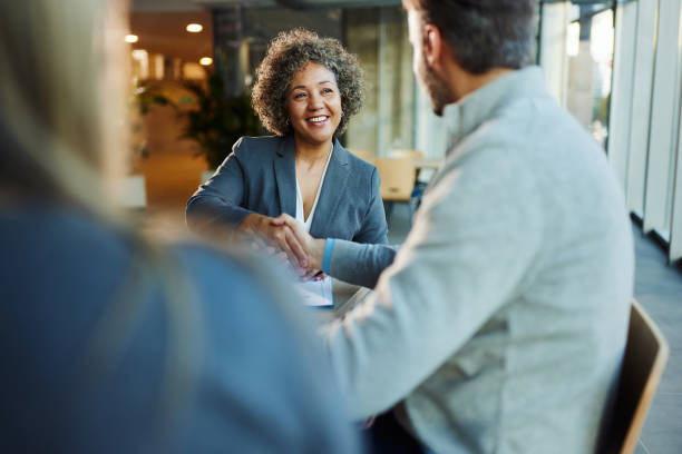 istock Happy insurance agent shaking hands with her customers in the office. 2153927587