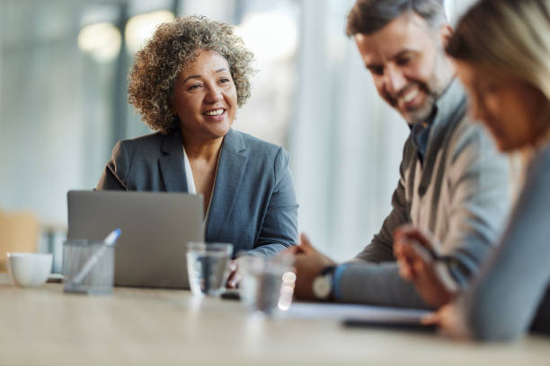 istock Happy insurance agent talking to her customers in the office. 2153927913