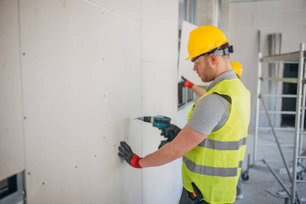 istock Precision at Work: Construction Worker Fastens Drywall with Electric Screwdriver 2153928328