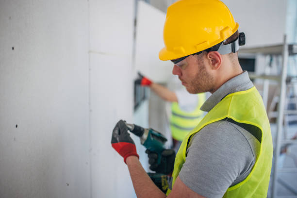 istock Precision at Work: Construction Worker Fastens Drywall with Electric Screwdriver 2153928473