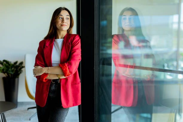 istock Confident young professional in red blazer smiling at modern office environment 2153929968
