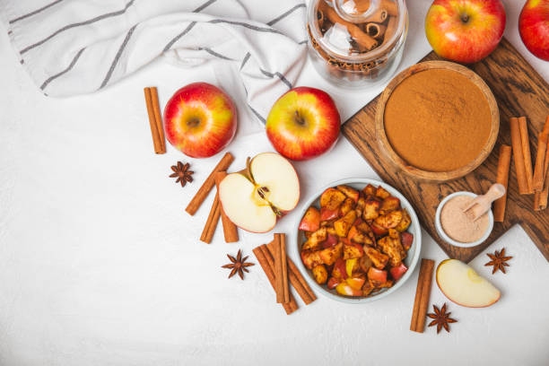 istock Apples with cinnamon on background. Fragrant red spiced apples with cinnamon sticks and star anise. Apple slices with spicy spices. Place for text. Copy space. Harvesting. Fruits. 2153932319