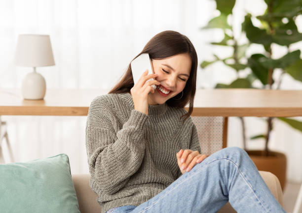 istock Carefree young lady have phone conversation at home 2153933277