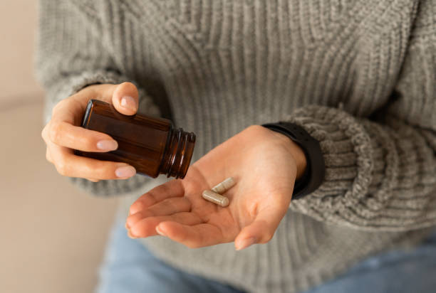 istock Woman hand holding glass jar with pills 2153933295