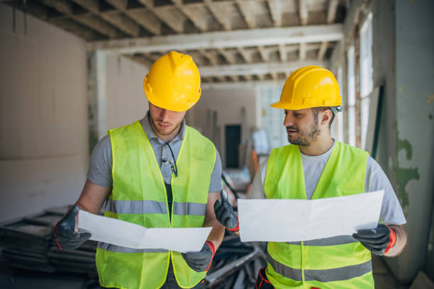 istock Strategic Planning on Site: Construction Workers Reviewing Blueprints 2153933688