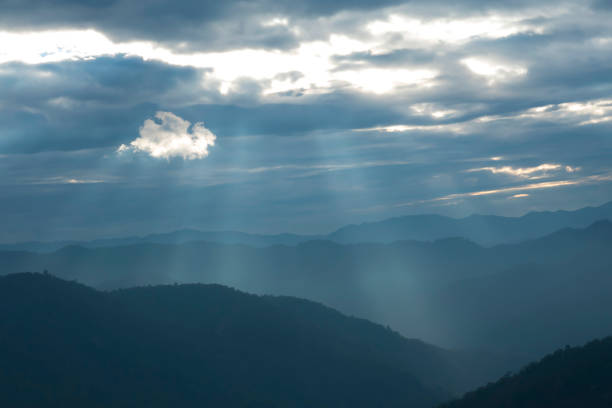 Sun rays filter through the clouds in hills of the valley illuminated by the sun's rays filtering through the clouds