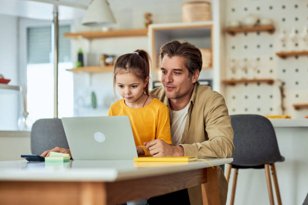 istock A patient father showing his work on a laptop to his daughter while she is typing 2153935118