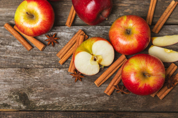 istock Apples with cinnamon on background. Fragrant red spiced apples with cinnamon sticks and star anise. Apple slices with spicy spices. Place for text. Copy space. Harvesting. Fruits. 2153935125