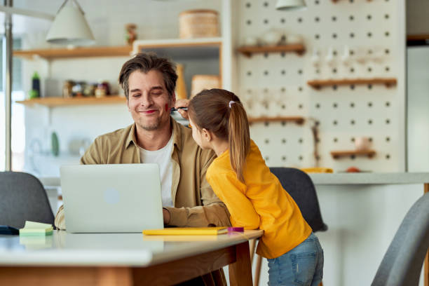 istock A single father working from home and letting his daughter play with makeup on his face 2153935186