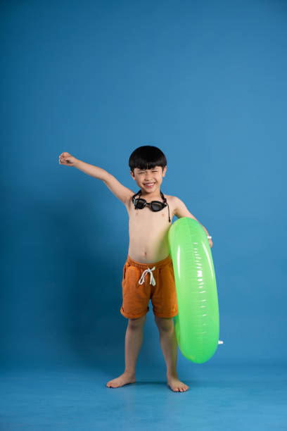 istock Portrait of asian boy posing on blue background 2153935470