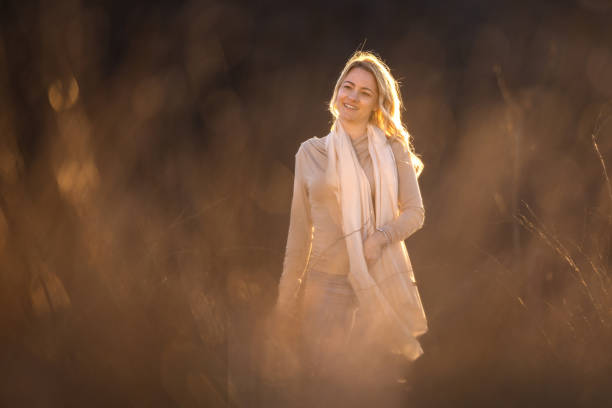 Happy mid adult woman walking in nature at sunset