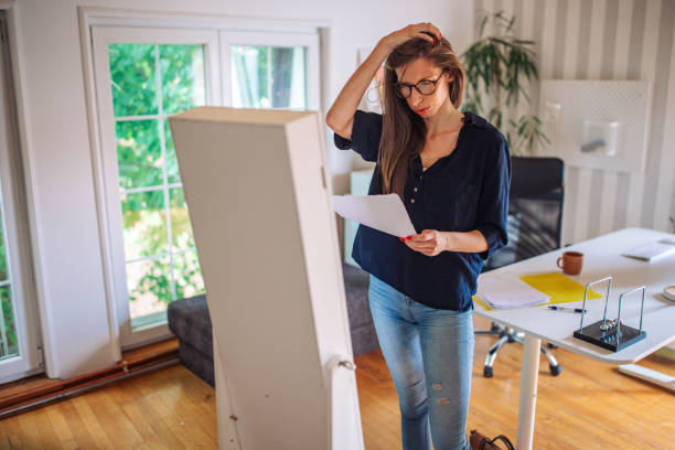 istock Concerned individual scrutinizing documents in a well-lit home office setting 2153936812