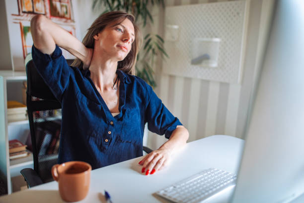 istock Workplace Discomfort: Woman Experiencing Neck Pain While Working from Home 2153939115