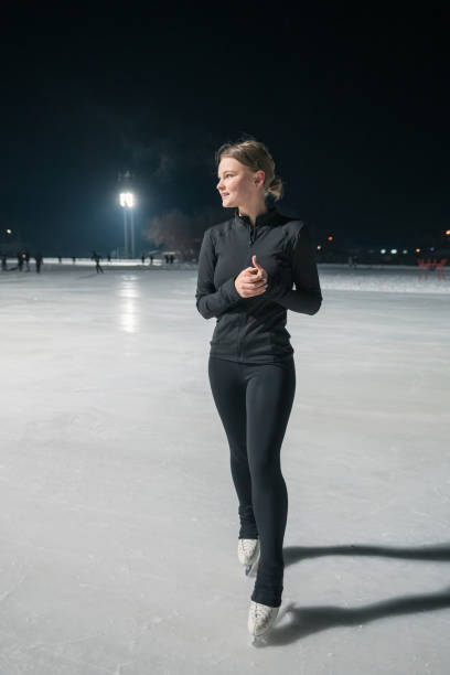 istock Beautiful young woman ice skating and performing short program 2153939152