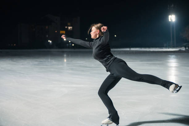 istock Beautiful young woman ice skating and performing short program 2153939164