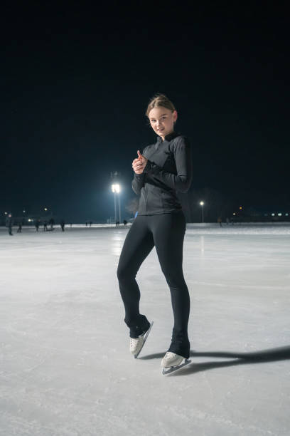 istock Beautiful young woman ice skating 2153939214