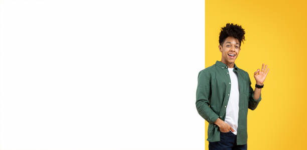 istock Cool positive young black guy standing by blank board 2153942196