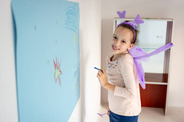 istock Girl holding crayon while drawing indoors 2153942330