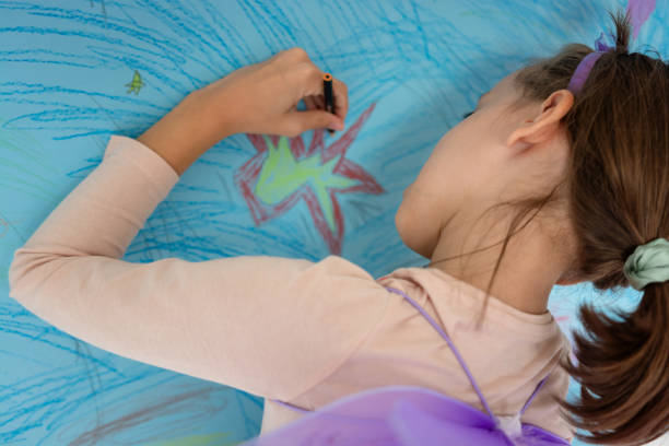 istock Girl dressed as a fairy drawing whit crayon 2153942502